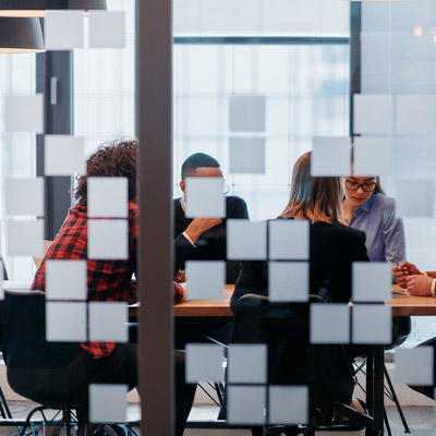 Discussion in a glass-walled meeting room, symbolising stakeholders reviewing insights with Oakford Group