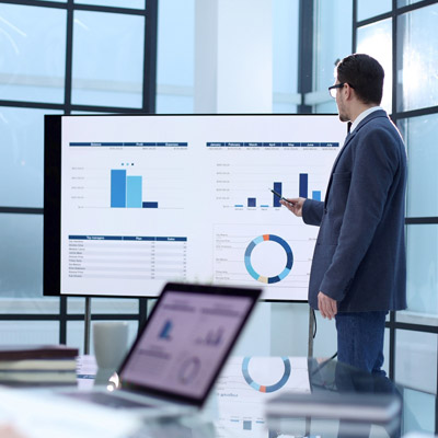 Delivering a presentation with business charts, representing a stakeholder sharing insights connected with Oakford Group