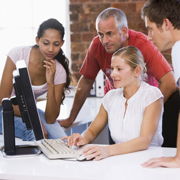 Stakeholders and partners of Oakford Group sharing ideas and reviewing property operations on a screen.